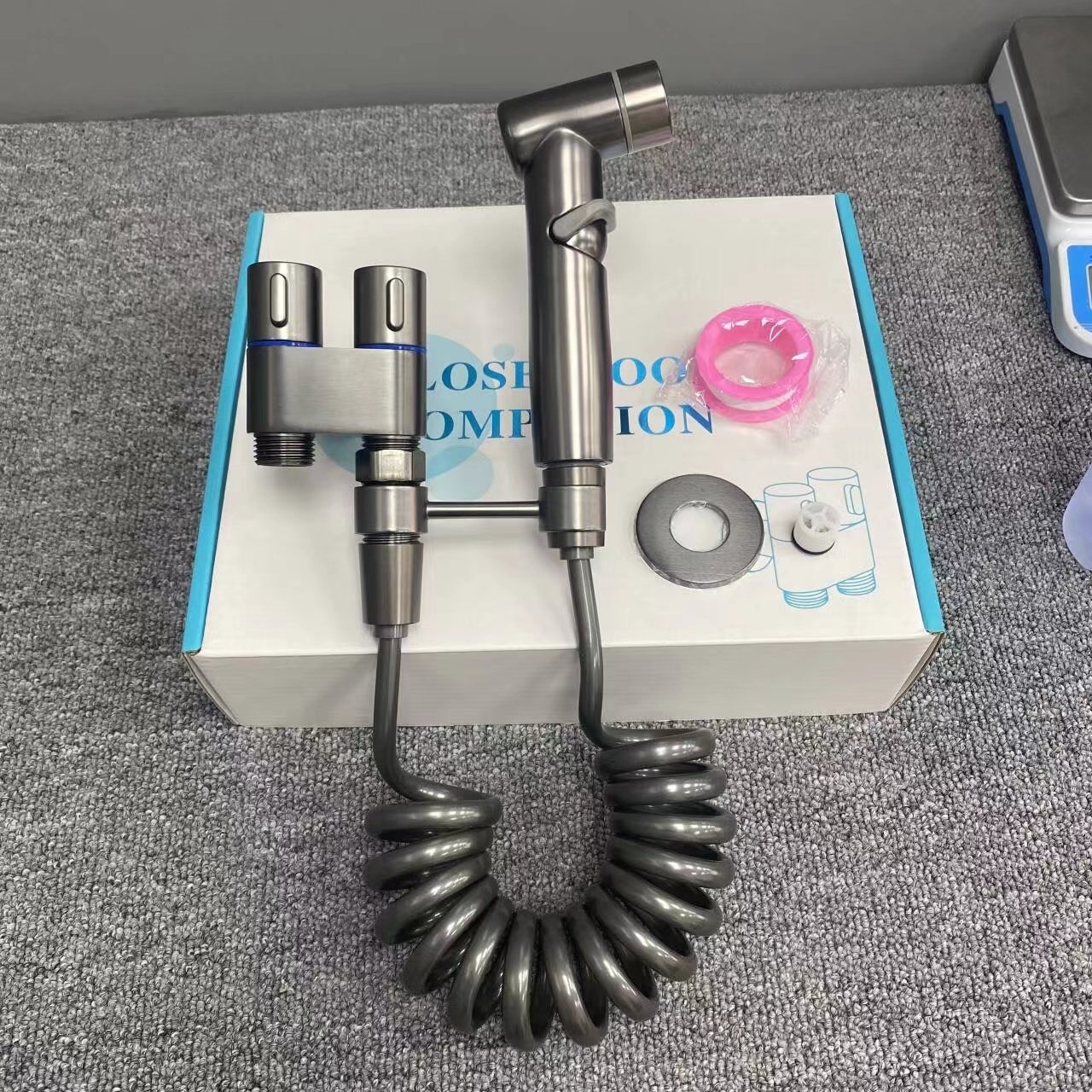 The spray gun next to the toilet suit the high-pressure nozzle to clean the flushing washer partner