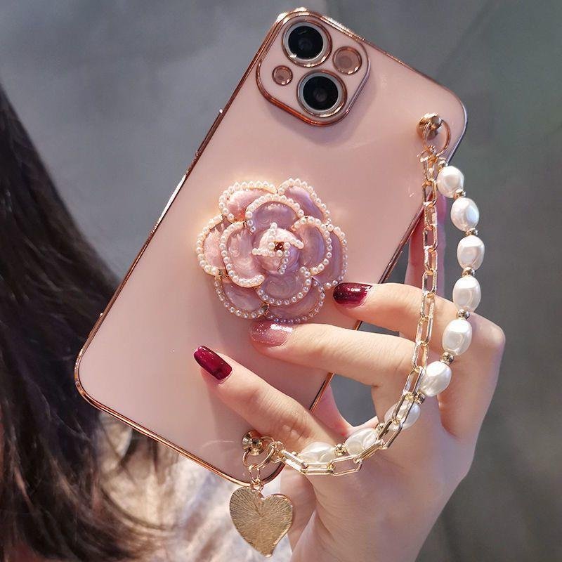 Popular with girls luxury rhinestone camellia with pearl hand chain TPU phone case for iphone 16 15 14 13 12 plus/pro/pro max