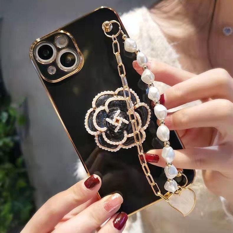 Popular with girls luxury rhinestone camellia with pearl hand chain TPU phone case for iphone 16 15 14 13 12 plus/pro/pro max