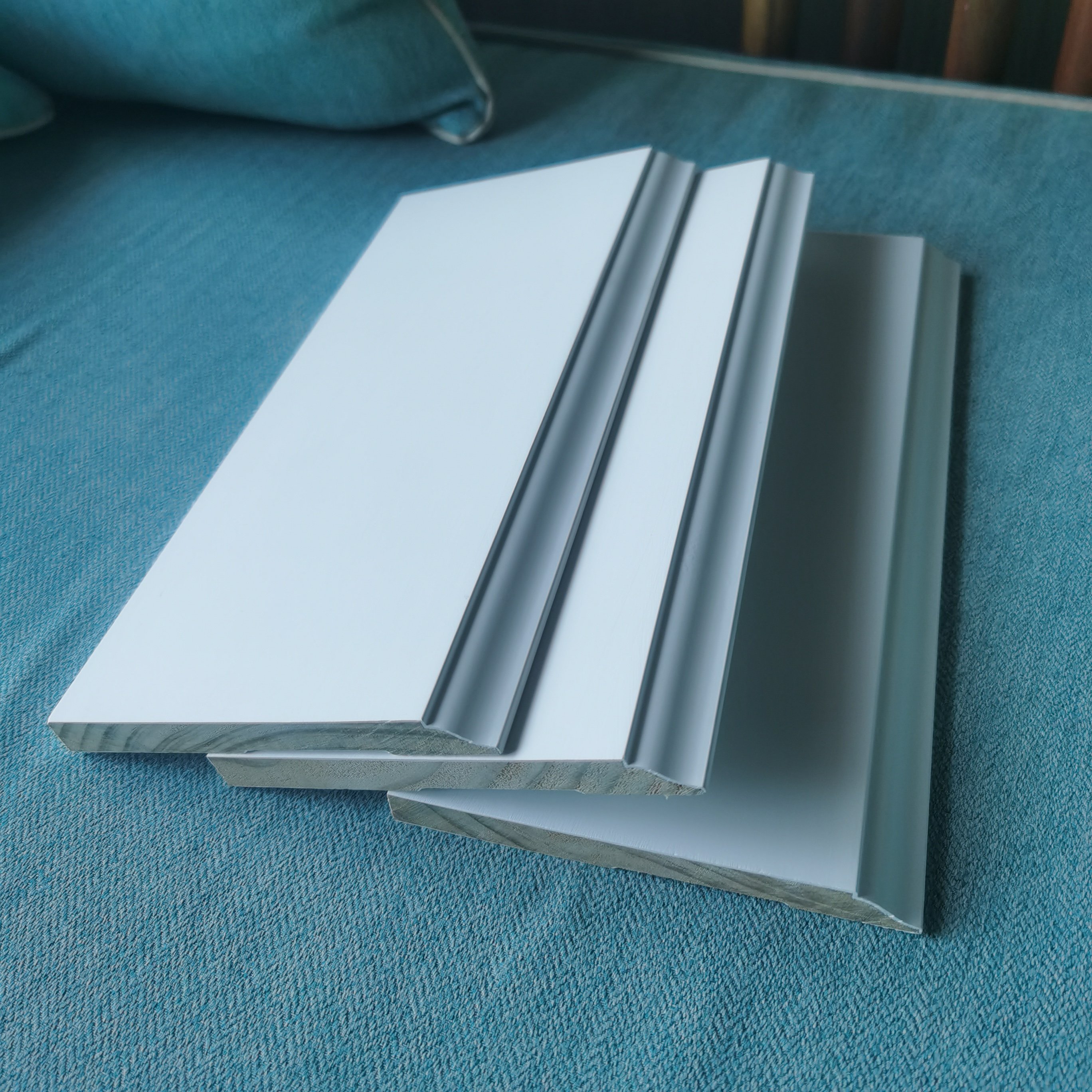 white gesso coating and primed pine door frame flat door jamb wooden baseboard skirting moulding