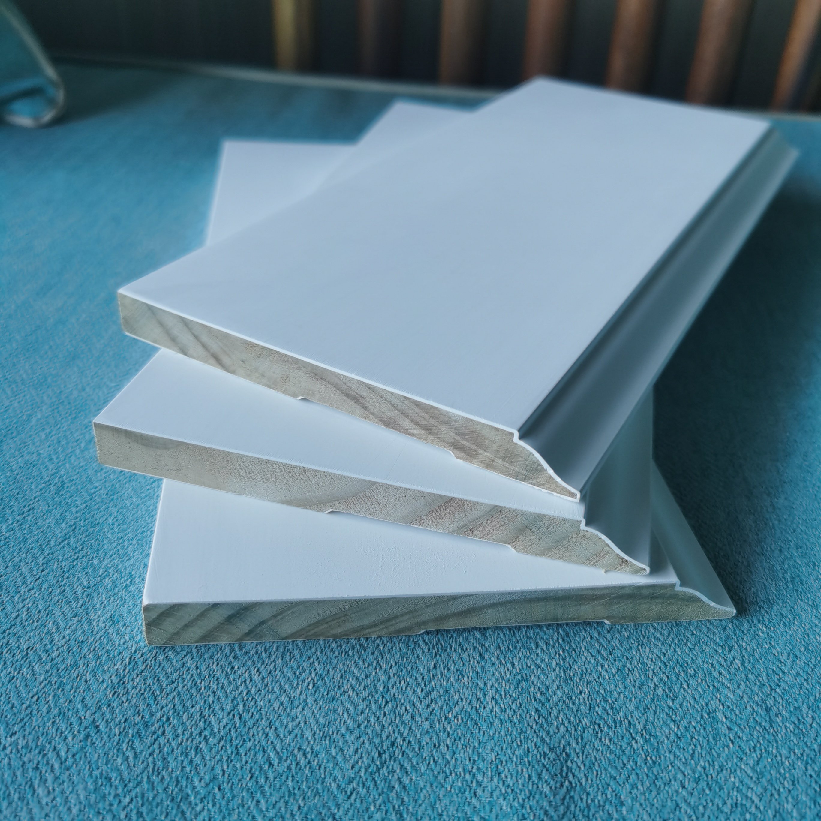 white gesso coating and primed pine door frame flat door jamb wooden baseboard skirting moulding