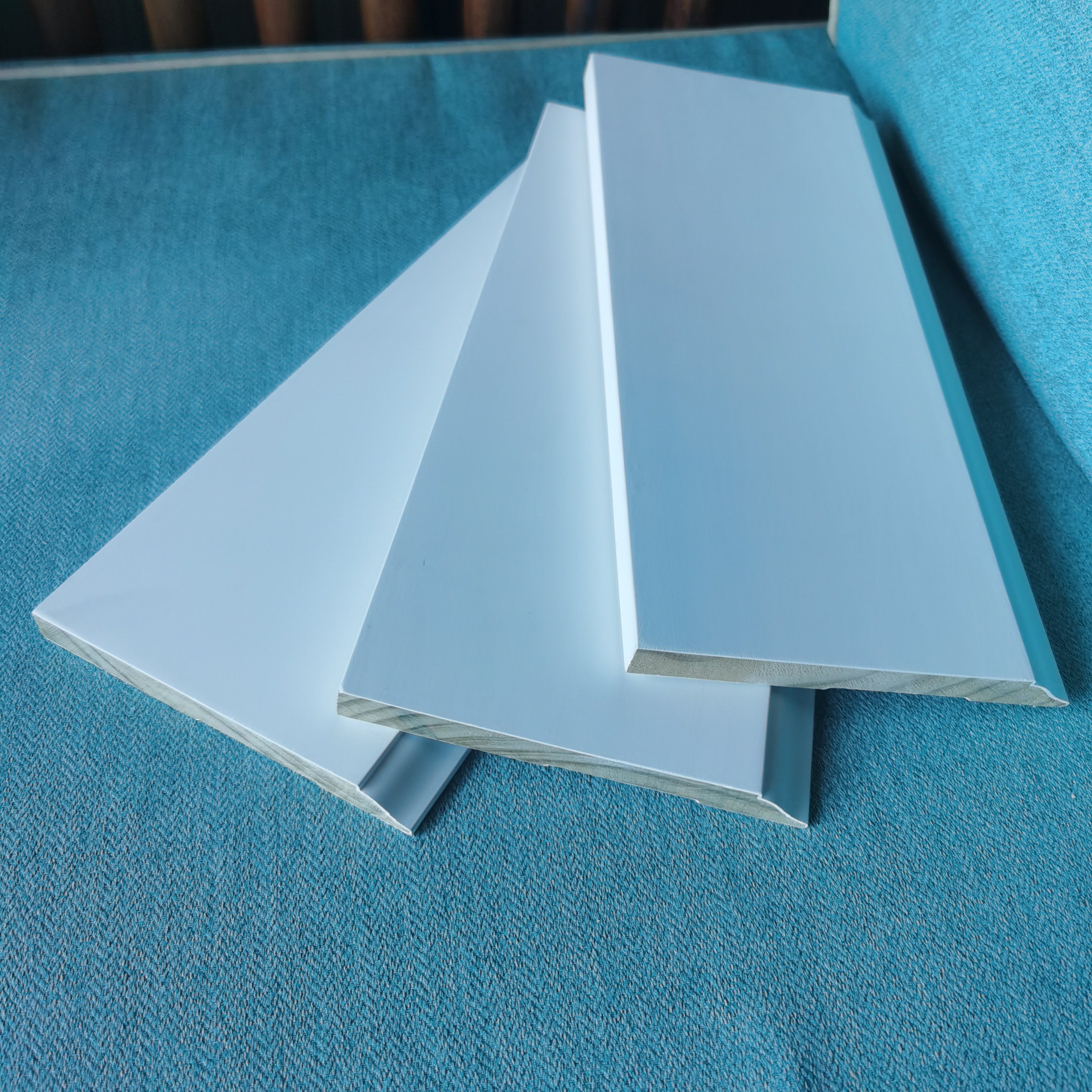 white gesso coating and primed pine door frame flat door jamb wooden baseboard skirting moulding