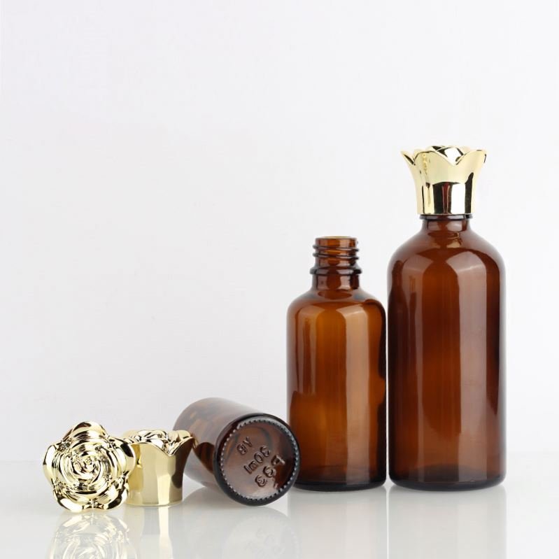 Hot selling cylindrical amber glass bottle with gold-plated rose cover and brown essential oil glass bottle