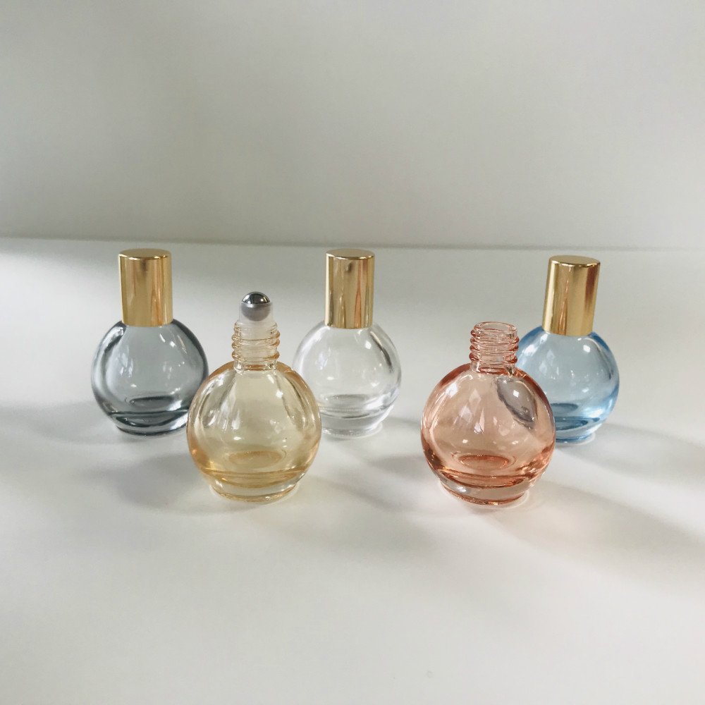 Wholesale 10ml rounded shape blue clear pink yellow grey metallic roll on essential oil glass bottle with shiny gold cap