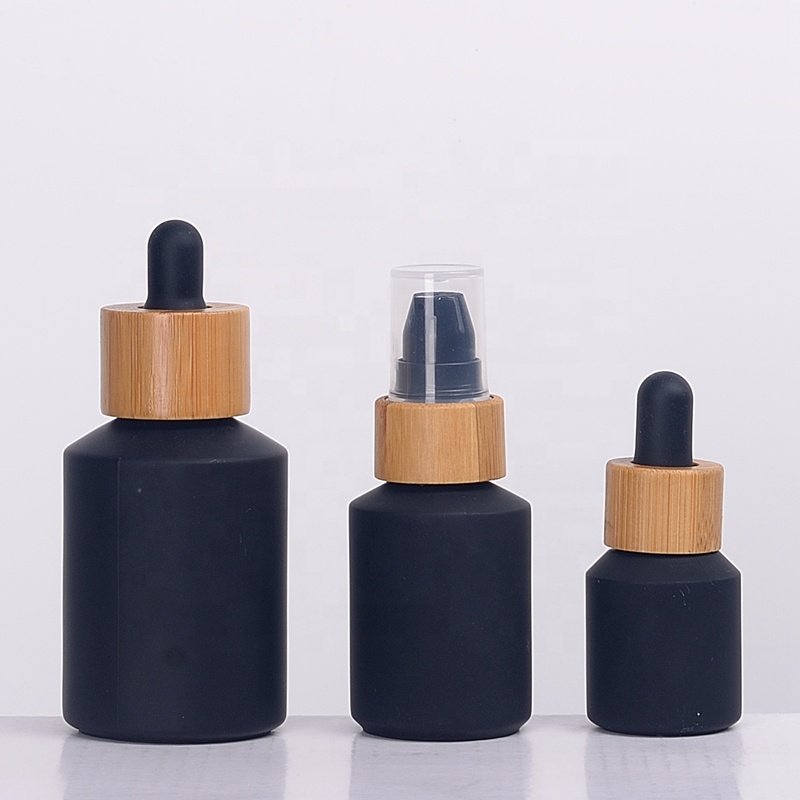 Inclined shoulder matte black glass bottle 30 ml 60 ml 100 ml cosmetic bottle and 15 gm 30 gm 50 gm glass jar with bamboo lid