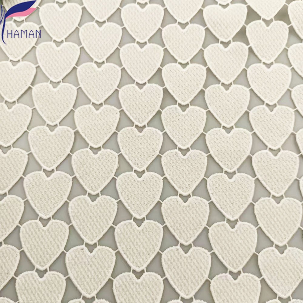 Exquisite hollow love pattern 100% polyester milk silk embroidery fabric for clothing and wallpaper