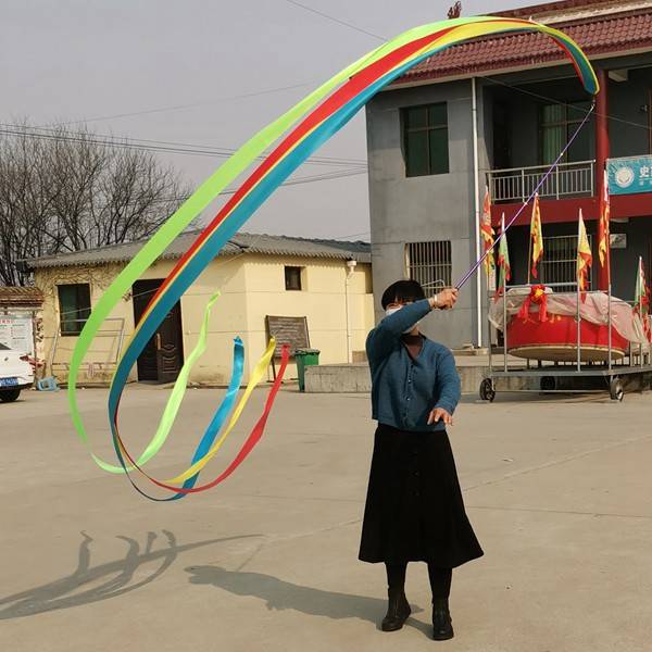 "Standing and gymnasium dance and choreography in the middle-aged square, with a colored silk ribbon and an outdoor adult art stretcher."