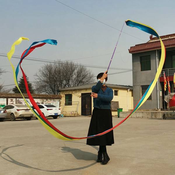 "Standing and gymnasium dance and choreography in the middle-aged square, with a colored silk ribbon and an outdoor adult art stretcher."