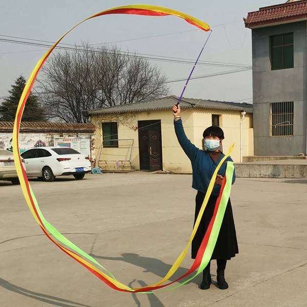 "Standing and gymnasium dance and choreography in the middle-aged square, with a colored silk ribbon and an outdoor adult art stretcher."