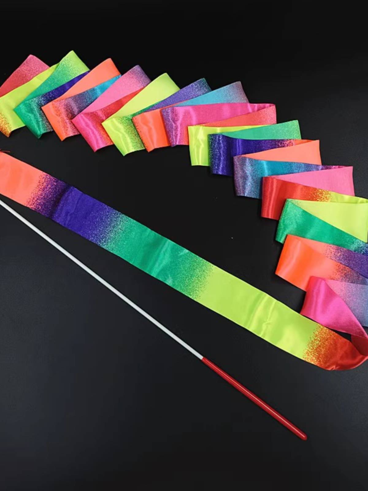 Promising gymnasium choreographer dances with sparkling silk and a professional ribbon with poles for adult children's stage shows
