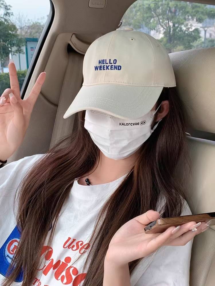 The duck tongue cap girl, 2024, with a little face, a little head around the sun and a big baseball hat