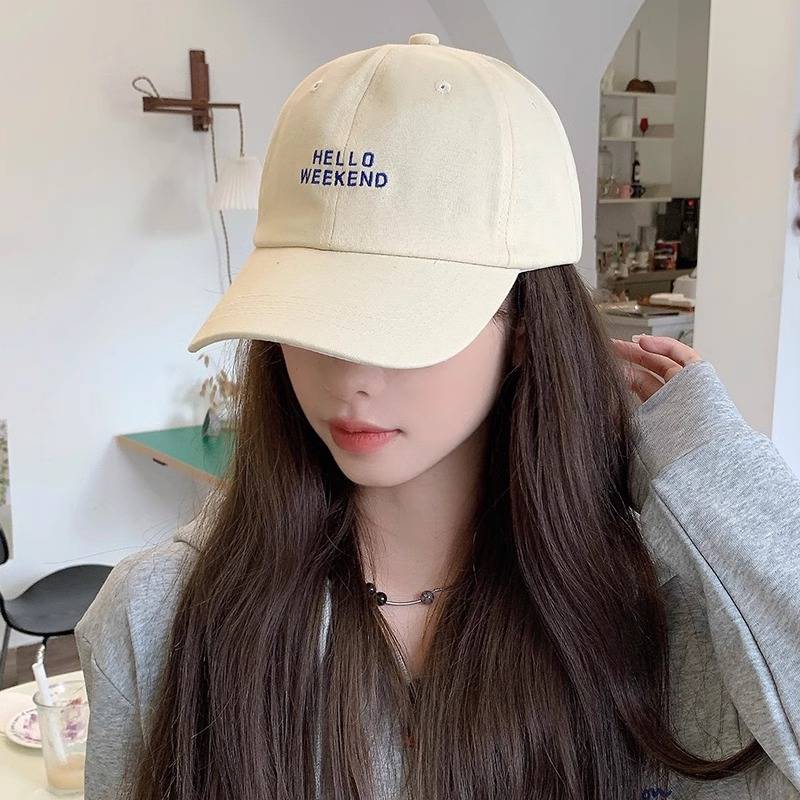 The duck tongue cap girl, 2024, with a little face, a little head around the sun and a big baseball hat