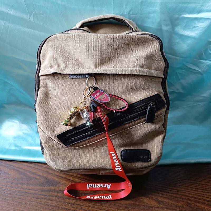 Arsenal's perimeter key buttoned to a little car-mounted backpack bag with a key chain for boys' hands-on football team