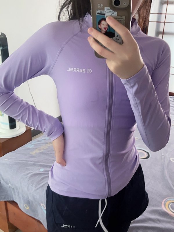 A lady with a full-body jellyfish divination suit, a sunscreen bathing suit and a purple surfing suit against chlorine pants