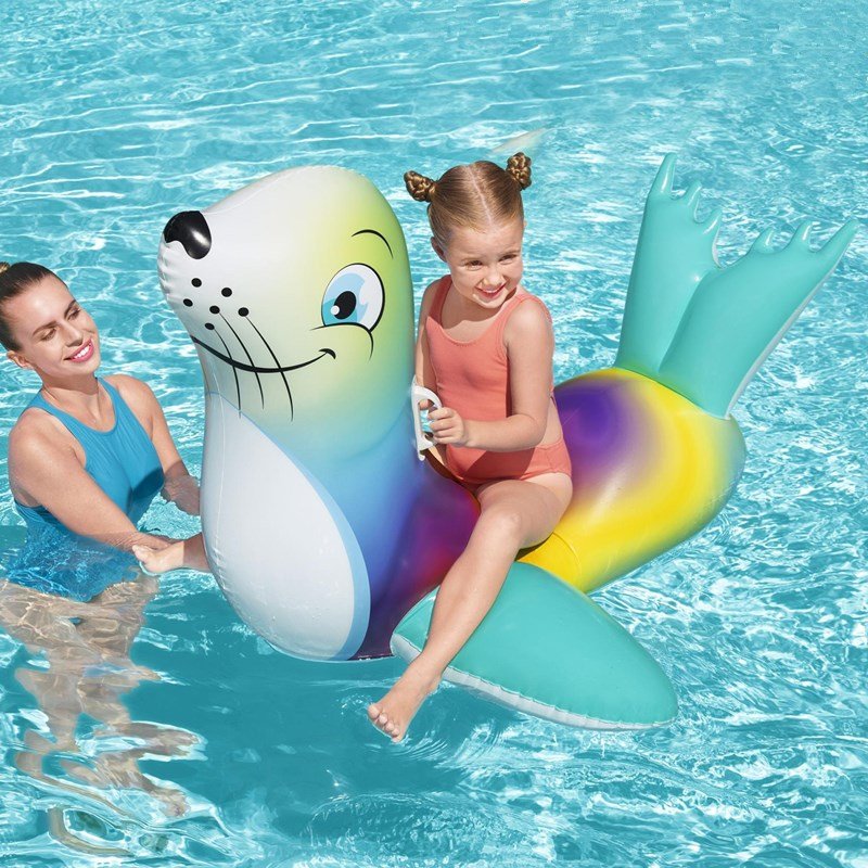 A LITTLE INFLATABLE SWIMMING RING FLUORESCENT SEALS RIDING A BABY BOY A TO PLAY WITH A CHILD SURFER