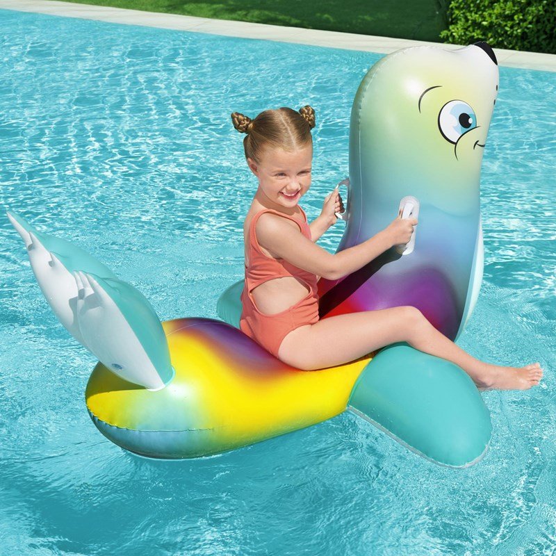 A LITTLE INFLATABLE SWIMMING RING FLUORESCENT SEALS RIDING A BABY BOY A TO PLAY WITH A CHILD SURFER