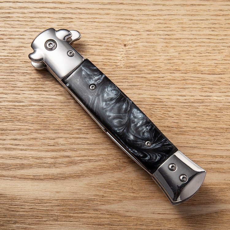 An outdoor steel-colored wood handle with a very hard folding of a fruit knife camping with a pedestal knife