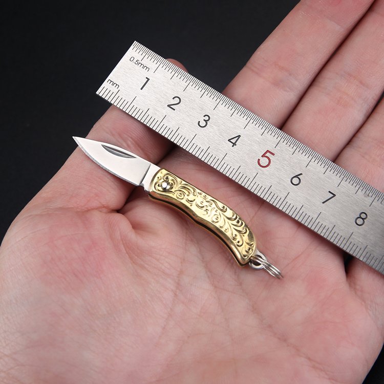 A hand-made mini-cleaver with a hand-carrying hand-carved knife, a pocket-carrying brass and fruit knife, and a key to a small knife