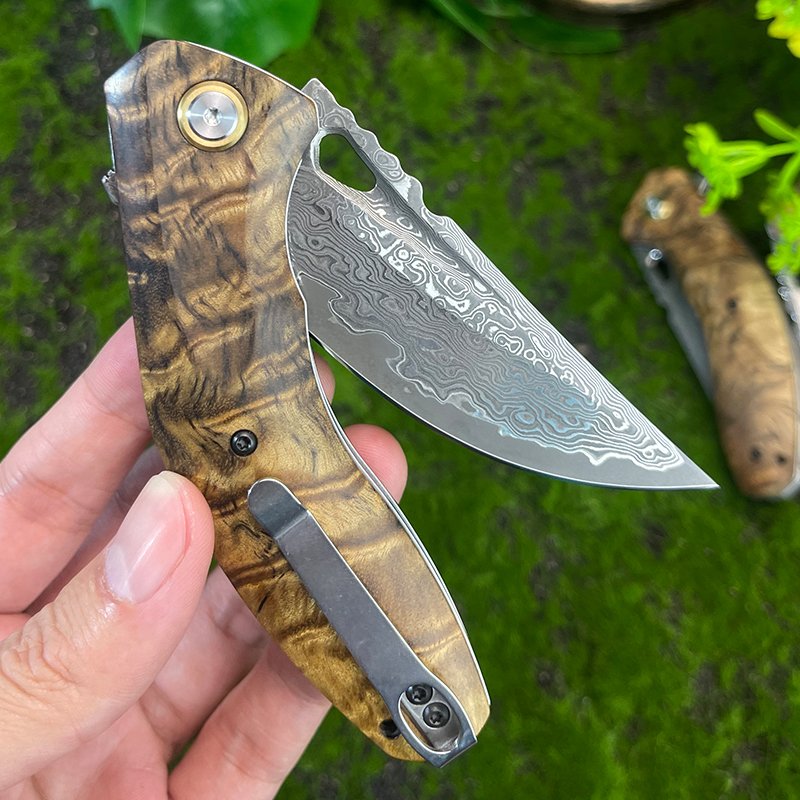 The Damascus steel field camping with a folding knife outside the house