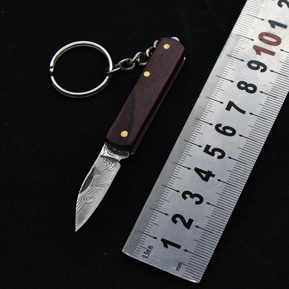 A small, folding knife, a practical fielding knife and a key-button with a mini-Damascus knife