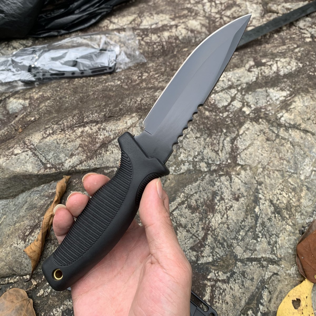 An outdoor knife with a multi-purpose straight blade and a high-intensity defensive knife camp