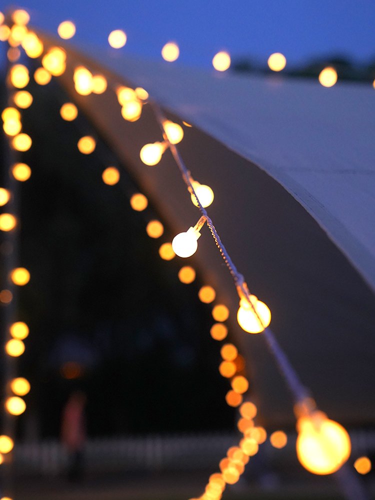 Solar camplights lined up with street-lighted and out-of-house camp lighting chandeliers