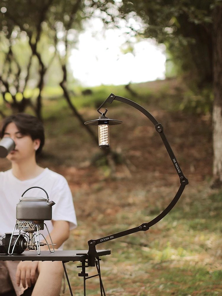 An outdoor camper table can fold over a shelf with multiple functions and a picnic stand
