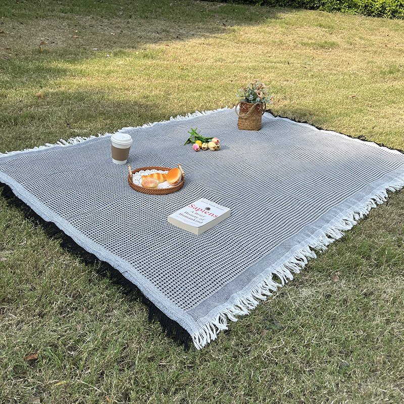 An outdoor picnic pad with a linen table and a blanket for a blanket