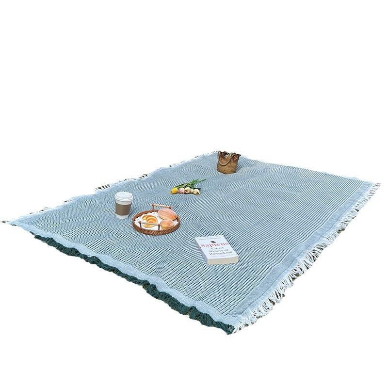 An outdoor picnic pad with a linen table and a blanket for a blanket