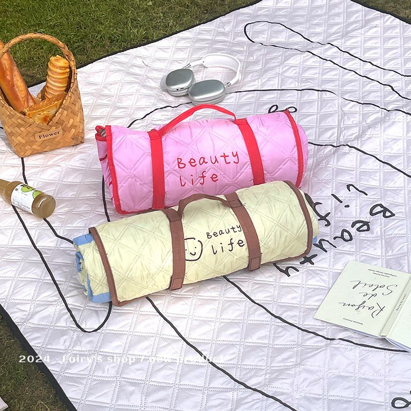 A picnic mat with a thick outdoor flood-proof pad folds and a camp mattress with a water-proof camper