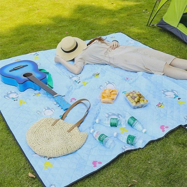 An outdoor picnic mat with an Oxford camper park tent folded