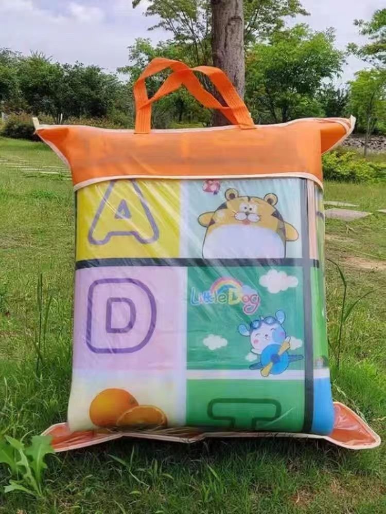 A bag of outdoor picnic mats and a thick camping camp with a spring field mat against the water and grass