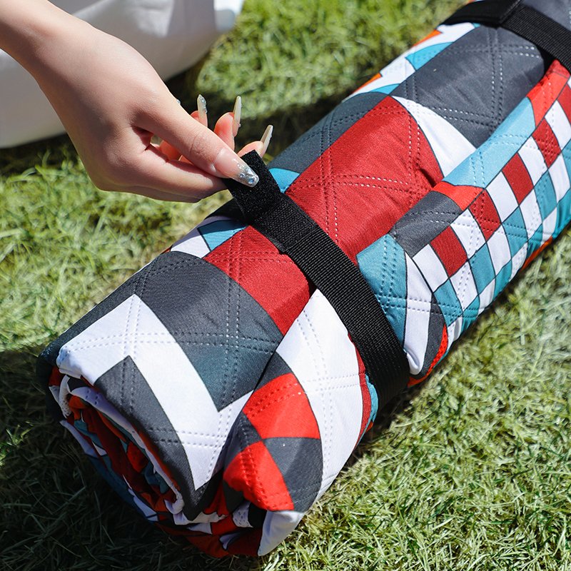 A picnic pad for the outdoors of the camping beach with water and a thick, wild lawn spring mat