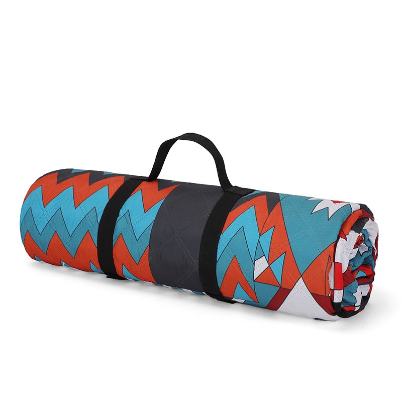 A picnic pad for the outdoors of the camping beach with water and a thick, wild lawn spring mat