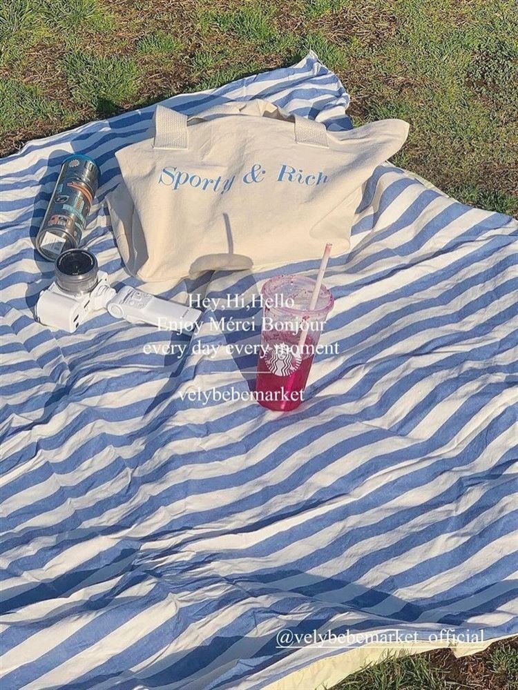 a striped picnic on a beach with a waterproof, sand-proof, open-sea-side camping pavilion with a tablecloth