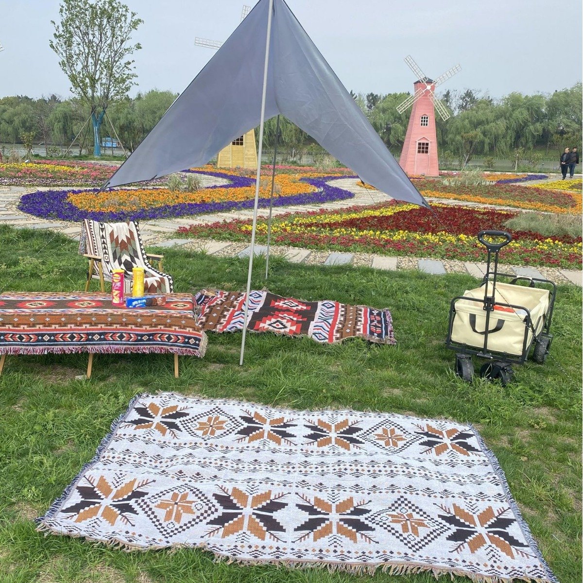 a picnic mat in a camping blanket and an outdoor pavilion of table decorations