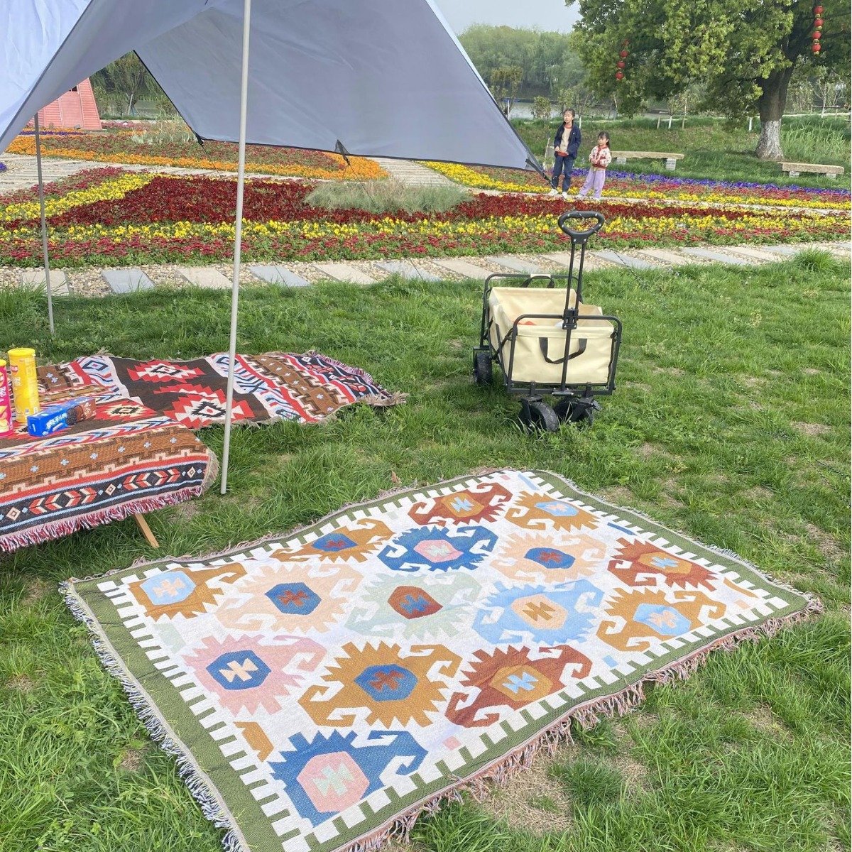 a picnic mat in a camping blanket and an outdoor pavilion of table decorations