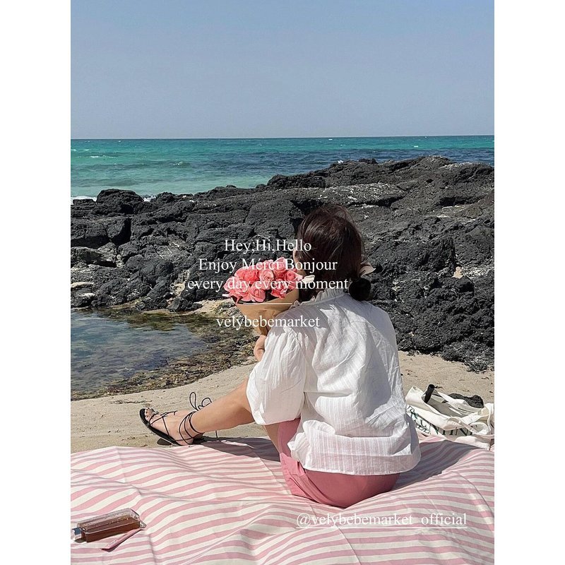 a striped picnic on a beach with a waterproof, sand-proof, open-sea-side camping pavilion with a tablecloth
