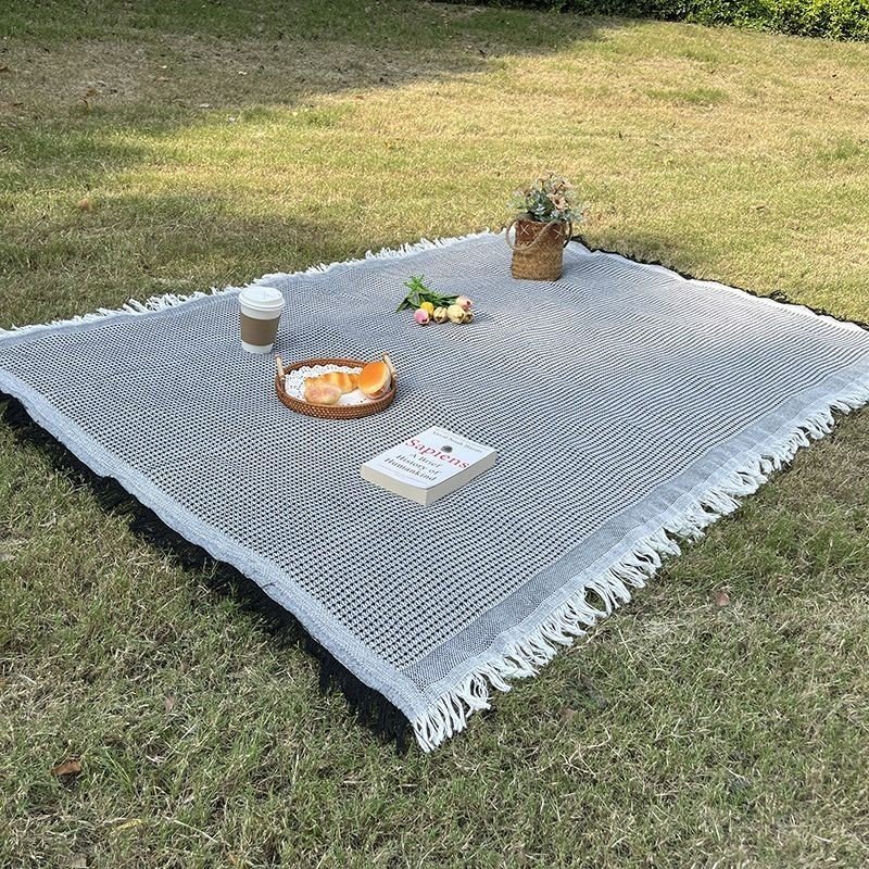 a picnic mat outside the house, with a thicker lawn, and a beach mat for the bonnet music festival