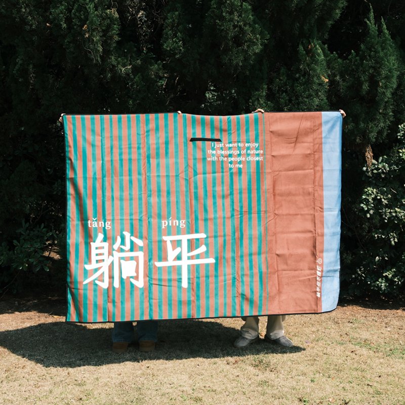 A picnic pad with a thick camper and a picnic mat and a beach mat folded to the back