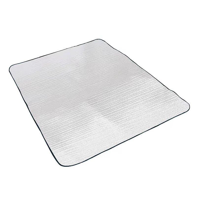 An aluminum membrane and a thick lawn picnic mat in an outdoor camping tent