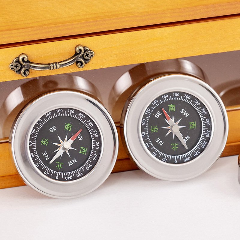 The stainless steel compass for outdoors points to the high-precision compass of the students on board the mountain