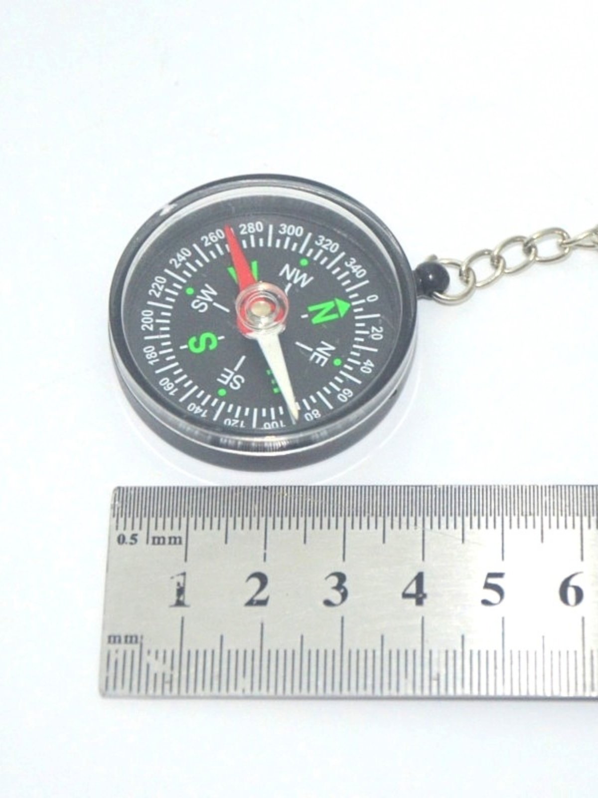 A car compass with a key button for a black student's outdoor school supplies indicates a printable northerly needle