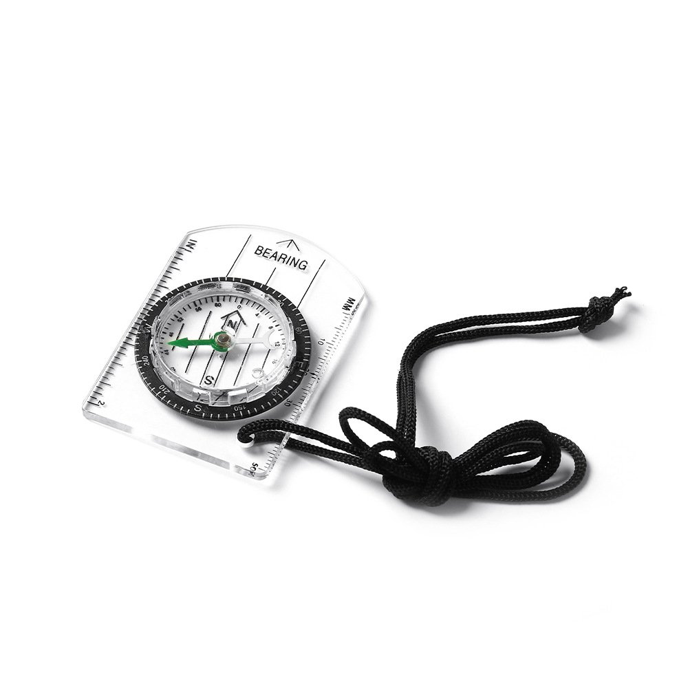 A professional multi-purpose compass for outdoor equipment in the wilderness points to a scale-scale compass of the north map
