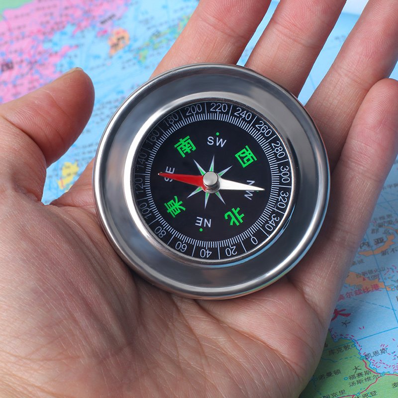 A car-borne compass for a child student pointing a sports compass to the north with a mini-precision outdoor non-night light