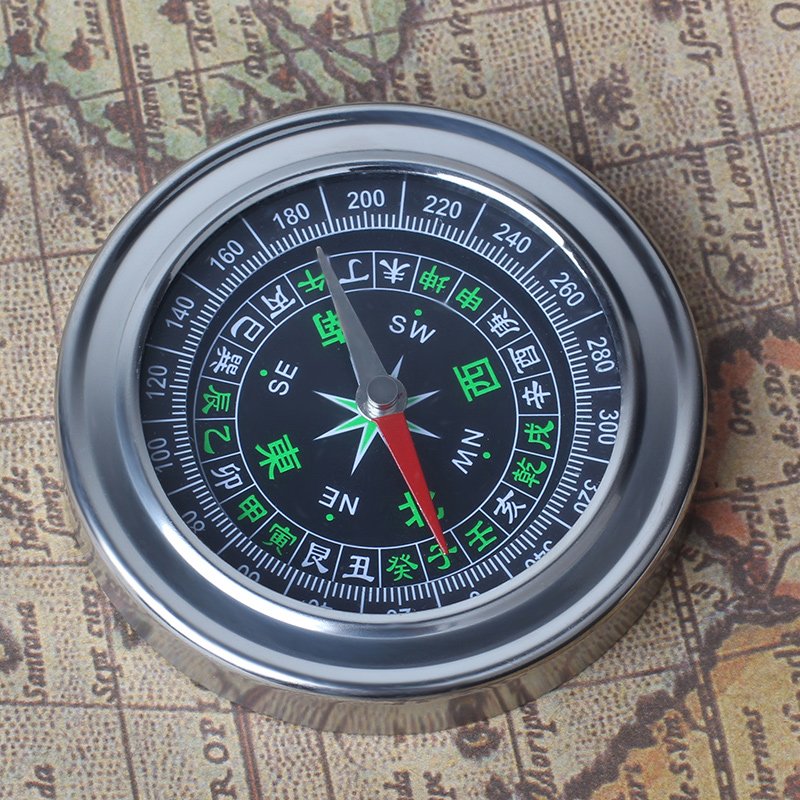 A car-borne compass for a child student pointing a sports compass to the north with a mini-precision outdoor non-night light