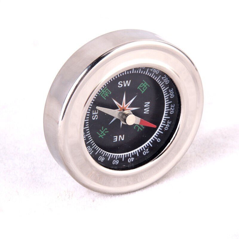 An outdoor multi-purpose bear-fired compass points to a metallic compass with a northern copper stainless steel