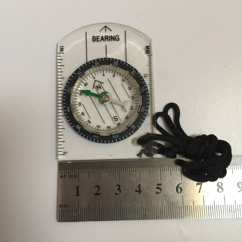 An outdoor multifunctional and transparent portable compass with a map of the compass and a northerly pointer