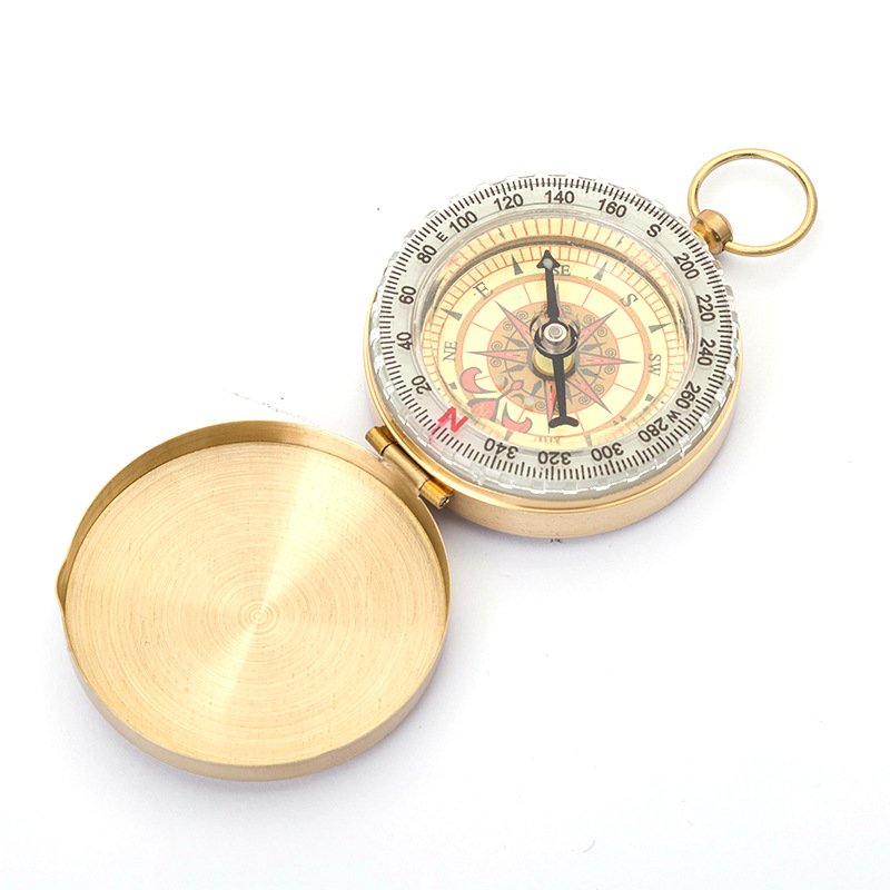 A camping guide with a night-light compass points to a northerly needle for emergency outdoor camping tools