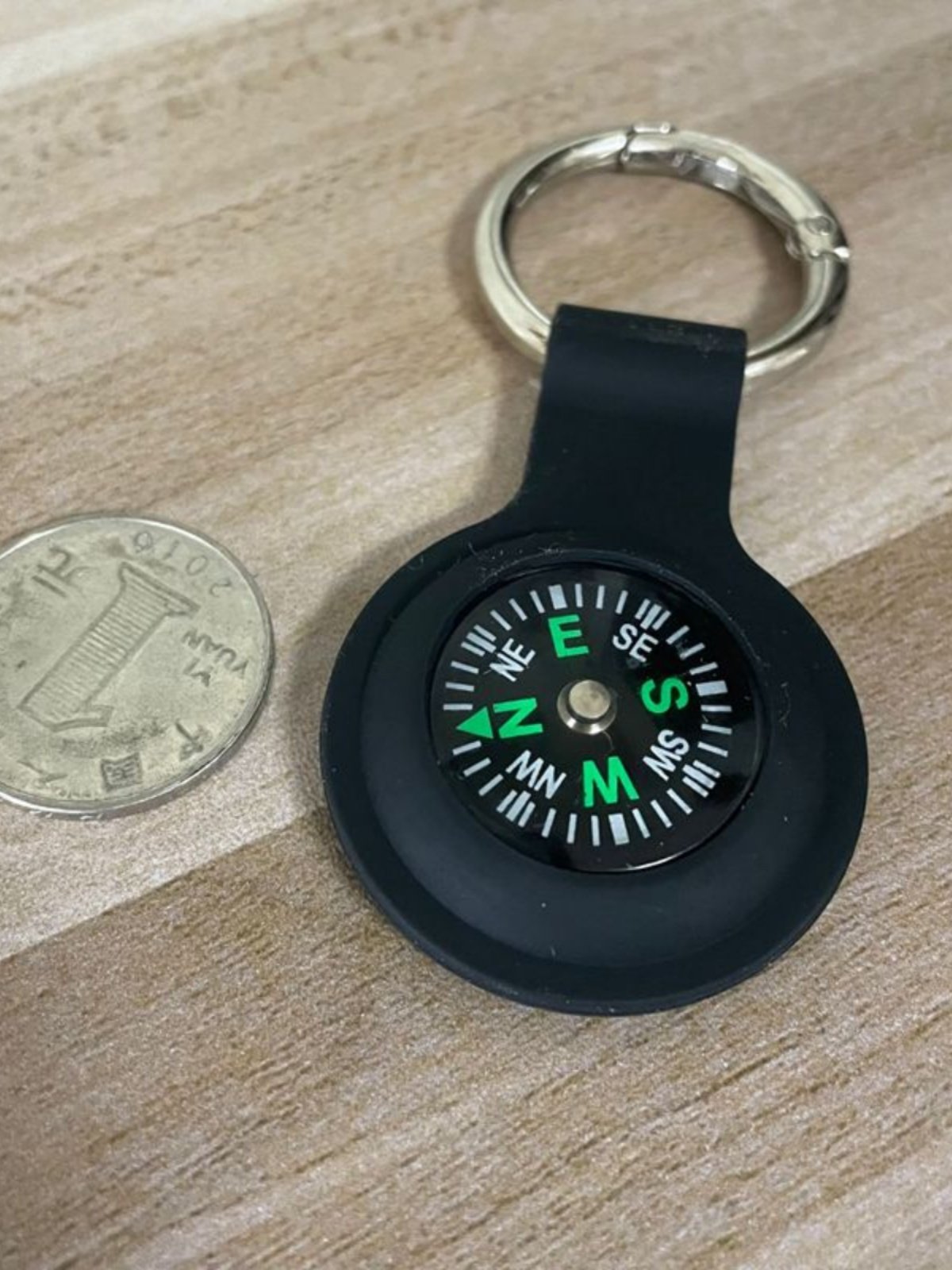 An outdoor navigation compass key to a necklace guide to a child student experiment with a northerly pointer